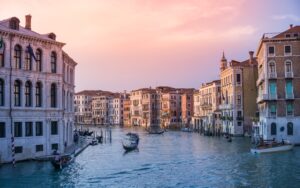 Gondolas On Body Of Water Between Buildings 